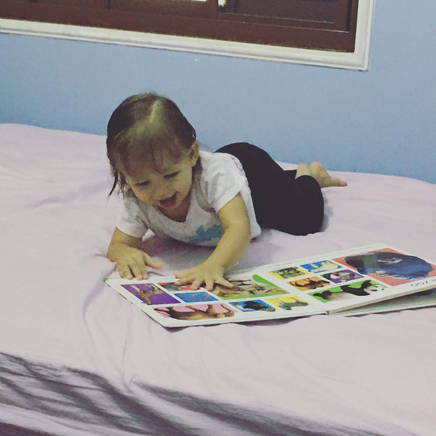 Noemi vendo livro na cama